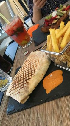 there is a sandwich and french fries on the table next to each other at this restaurant