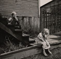 a black and white photo of two children sitting on steps