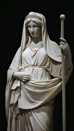 a statue of the virgin mary holding a staff