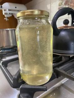 a jar filled with liquid sitting on top of a stove