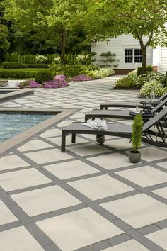 an outdoor patio with benches and pool in the background