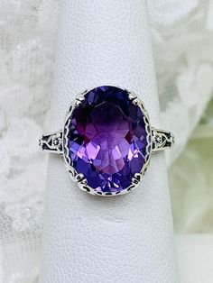 Natural Purple Amethyst Ring *(with Optional Band Upgrade) Edward Design#70 Custom Made Inspired by Edwardian jewelry of the early 1900s, I now offer this lovely Antique reproduction ring in sterling silver. This gorgeous ring is set with a stunning Natural purple amethyst gemstone. This genuine amethyst has excellent color and clarity. The oval cut 3.7ct amethyst is 14mm (9/16th of an inch) Long by 10mm Wide (3/8th"), (slightly smaller gemstone also available upon request). The ring sits 6mm of Swag Design, Purple Amethyst Ring, Edwardian Jewelry, Order Design, Gorgeous Ring, Vintage Style Rings, Engraved Items, Early 1900s, Amethyst Gemstone