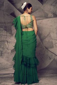 Green georgette sharara draped saree adorned with organza ruffles. Comes with padded blouse with mirror work, kasab gold thread and gota thread work embroidery.
Components: 2
Pattern: Embroidered
Type Of Work: Mirror, thread, gota
Neckline: Plunged V
Sleeve Type: Sleeveless
Fabric: Sharara and Drape: Georgette, Blouse: Silk, Ruffle: Organza
Color: Green
Other Details: 
Back tie-ups
Tiered sharara
Occasion: Destination Wedding - Aza Fashions Fitted Ruffled Blouse Piece For Navratri, Fitted Ruffle Blouse Piece For Navratri, Green Sharara With Mirror Work And Traditional Drape, Fitted Ruffled Blouse For Navratri, Pista Green Georgette Pre-draped Saree With Mirror Work, Green Sleeveless Sharara With Mirror Work, Green Sharara With Cutdana Details, Semi-stitched Green Sharara With Cutdana Details, Blouse Organza