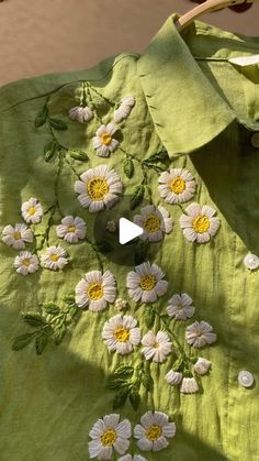 a green shirt with white daisies on it