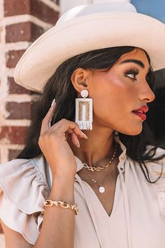 All eyes are sure to be on you when you accessorize with our stunning 'Malibu Pier' statement earrings featuring white and gold beaded circle studs, dangling rectangle pieces, and fringe detailing! Trendy White Tassel Drop Earrings, Bohemian White Beaded Earrings, White Bohemian Rectangular Earrings, Bohemian White Rectangular Earrings, White Beaded Fringe Tassel Earrings For Beach, Trendy White Dangling Beads Earrings, Trendy White Dangling Bead Earrings, Trendy White Earrings With Dangling Beads, White Beaded Fringe Tassel Drop Earrings