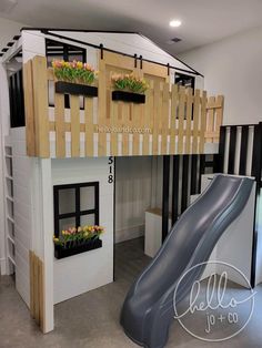 there is a loft bed with a slide and flower boxes on the bottom level,