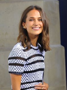 a smiling woman in a black and white dress