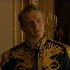 a man in a black and gold jacket looking at the camera