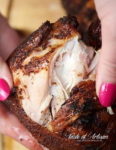 a close up of a person holding food in their hands with pink nail polishes