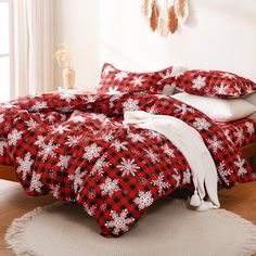 a red and black plaid bed spread with snowflakes on the comforter in a bedroom