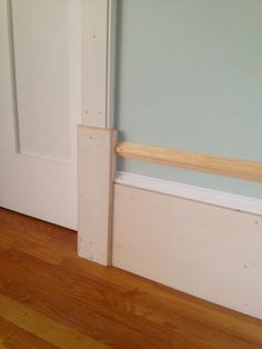 an empty room with wood flooring and white door frame on the wall next to it