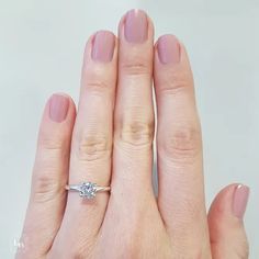 a woman's hand with a diamond ring on her left and the other hand holding an engagement ring