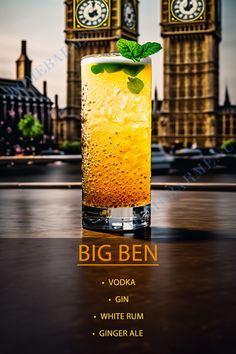 a tall glass filled with ice and mint sitting on top of a table in front of big ben