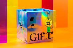 a gift bag with a tag on it sitting in front of some colored walls and flooring