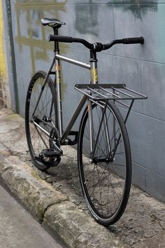 a bike leaning against a wall on the side of a street in front of a building