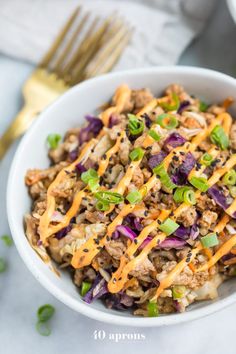 a white bowl filled with coleslaw and meat on top of a marble table