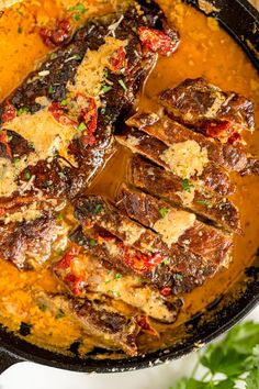 a skillet filled with meat and sauce on top of a table