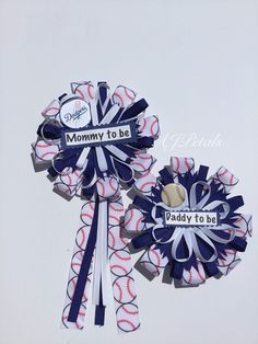 two baseball themed hair bows with the words mommy to be and daddy to be on them