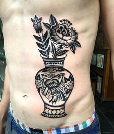 a man with a flower vase tattoo on his stomach