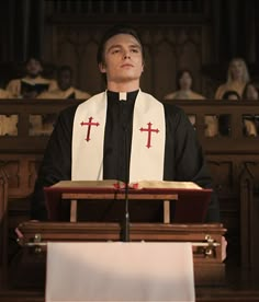 a man in a priest's outfit standing at the alter