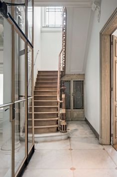 an open door leading up to a set of stairs in a building with glass doors