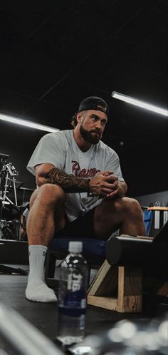 a man sitting on top of a bench in a gym