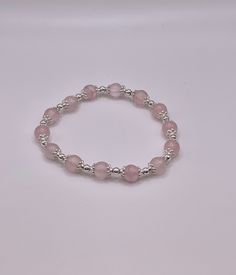 This is a Beaded Bracelet that adjusts to any size wrist.  Rose Quartz round beads with silver spacers Single layer - 7.5 inch Elastic Bracelet This is a Beautiful Elastic style Bracelet. This Bracelet wrap 7.5 inches around your wrist and is a great piece to add to your jewelry collection. beads are about 8mm. You will receive a nylon gift bag for your gift giving. You will choose gift bag color at checkout. If you have any questions send me a message. Silver Hypoallergenic Stretch Bracelet For Healing, Silver Hypoallergenic Stretch Bracelet, Adjustable Polished Bead Crystal Bracelet, Adjustable Polished Beads Crystal Bracelet, Adjustable Silver Beaded Bracelet With Gemstone Beads, Adjustable Round Crystal Bracelet With Polished Beads, Adjustable Rondelle Crystal Bracelet With 8mm Beads, Adjustable Crystal Bracelet With Round Beads And Extender, Adjustable Silver Beads Bracelet