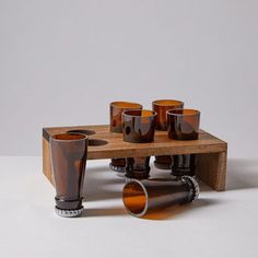 a wooden table topped with lots of glasses and vases on top of each other