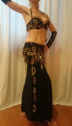 a belly dancer in black and gold costume