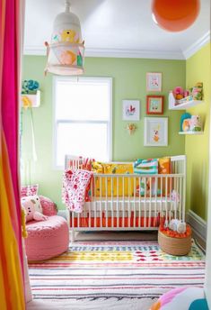 a baby's room with green walls and pink accents