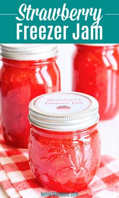 strawberry freezer jam in mason jars on a checkered tablecloth with text overlay