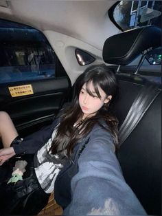 a woman sitting in the back seat of a car