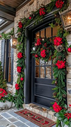 the front door is decorated with red poinsettis and greenery