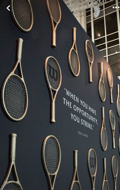 there are many tennis rackets on display in the building's exhibit area,