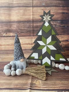 a small christmas tree sitting on top of a wooden table next to balls and a broom