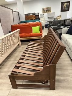 a wooden bed frame sitting on top of a hard wood floor in a living room