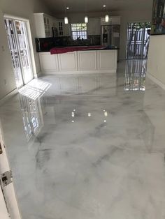 an empty room with white cabinets and marble floors