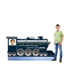 a young boy standing next to a cardboard replica of a thomas the tank engine train