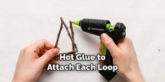 two hands are holding a pair of twig with the words hot glue to attach each loop