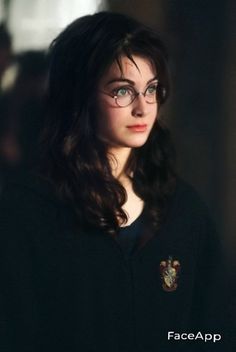 a woman with glasses and long dark hair is staring at the camera while wearing a harry potter sweater