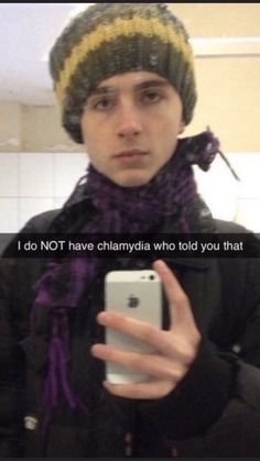 a young man wearing a hat and scarf holding a cell phone in front of him with the caption, i do not have chlamydiadia who told you that