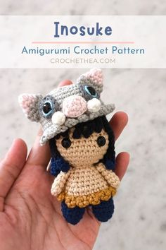 an amigurmi crochet doll is wearing a hat and holding it in her hand