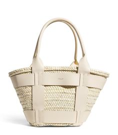 Find DEMELLIER Raffia Santorini Tote Bag on Editorialist. The Demellier Santorini tote bag is crafted from natural palm leaves and is handwoven in Morocco. The bag features a woven design and top handles. It embodies the brand's commitment to sustainable and artisanal practices. London Logo, Leather Harness, Natural Baskets, Bag Trends, Raffia Bag, Trainer Boots, Boots Knee, Palm Leaves, Santorini