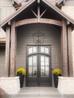 the front entrance to a house with two planters