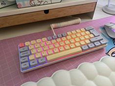 a computer keyboard and mouse on a pink table with hello kitty stickers in the background