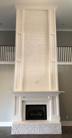 a white fireplace in a living room with two balconies