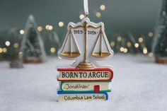 a christmas ornament with two books stacked on top of each other in the snow