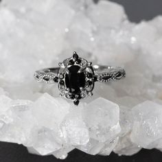 a black and white diamond ring sitting on top of some ice crystals in front of the camera