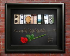 the word brother written in letterpress with a single red rose on a brick wall