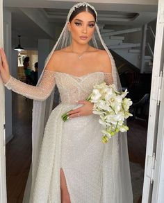 a woman in a white wedding dress with flowers on her head and veil over her face